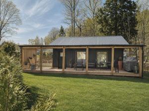 a large wooden house with a deck in a yard at Ljungskile modern country lodge in Grötån