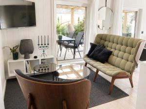 a living room with a couch and a table at Ljungskile modern country lodge in Grötån