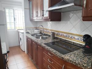 a kitchen with a sink and a counter top at Piso Calatrava in Chipiona