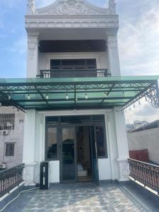 a building with a glass door and a balcony at Willow Stay in Hai Phong
