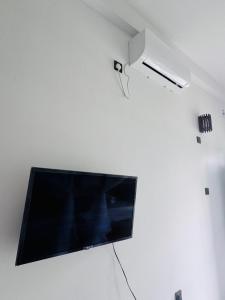a flat screen tv hanging on a white wall at Hotel Elysian in Udawalawe