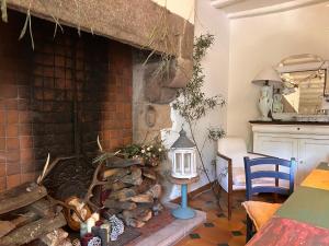 a living room with a brick fireplace and a table at Le presbytère in Le Crouais