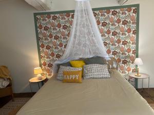 a bedroom with a bed with a happy pillow on it at Le presbytère in Le Crouais