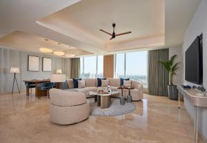 a living room with a couch and a tv at The Forum Hotel and Convention in Ahmedabad