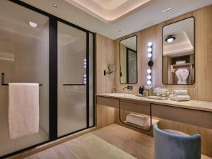 a bathroom with a sink and a mirror at The Forum Hotel and Convention in Ahmedabad +55 photos