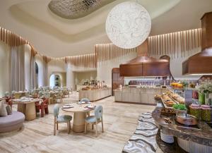 a restaurant with tables and chairs and a buffet at The Forum Hotel and Convention in Ahmedabad