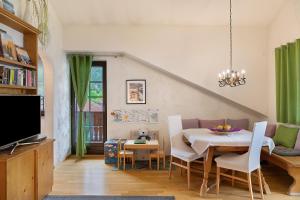 a dining room with a table and a tv at Appartement Azalea Oetz in Oetz