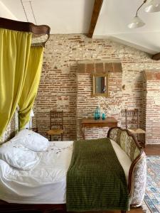 a bedroom with a bed and a brick wall at Manoir La Bordeneuve in Villeneuve-sur-Lot +32 photos