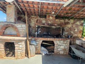 an outdoor brick oven with a stone wall at Vila 3 palmat in Ksamil