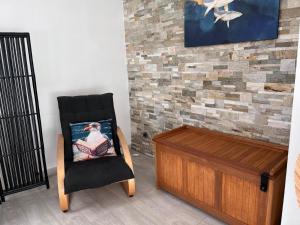a black chair and a wooden chest in a room at La Mouette Bleue maison de ville individuelle et climatisée in Martigues