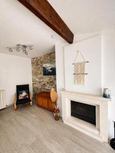 a living room with a fireplace and a chair at La Mouette Bleue maison de ville individuelle et climatisée in Martigues