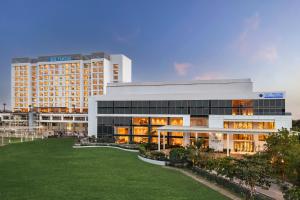 a large building with a lawn in front of it at The Forum Hotel and Convention in Ahmedabad