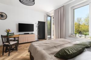 a bedroom with a bed and a desk and a tv at Oliwa Am Calsberg 5a in Gdańsk