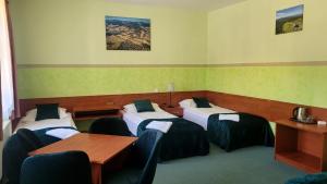 a room with four beds and a table and chairs at Willa Akme in Stronie Śląskie