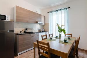 a kitchen with a table with chairs and a refrigerator at Blue Terrace Guest House in Alghero