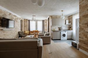 a living room with a couch and a kitchen at Arya Pansiyon Konyaaltı in Antalya