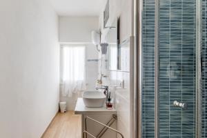 a bathroom with a sink and a glass shower at Blue Terrace Guest House in Alghero +50 photos