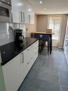 a kitchen with white cabinets and a table with chairs at Charmigt in Gränna