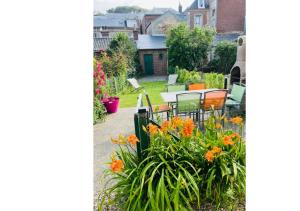 a garden with a table and chairs and flowers at Maison de pêcheur in Étretat
