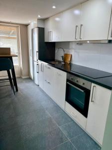 a kitchen with white cabinets and a black counter top at Charmigt in Gränna +3 photos