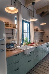 a kitchen with white cabinets and a sink and a window at Tropianka - sielski dom na skraju wsi in Tropie
