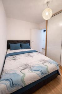 a bedroom with a large bed with a painting on it at Apartman MATEJ in Vranješ
