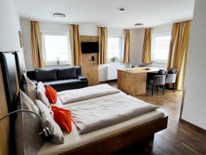 a bedroom with a bed and a living room at Pension Sperlhof in Erding
