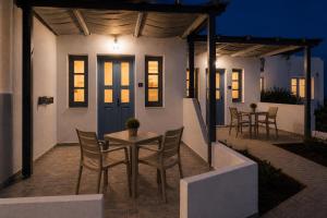 a patio with a table and chairs at night at Mare Nostrum Santo in Oia