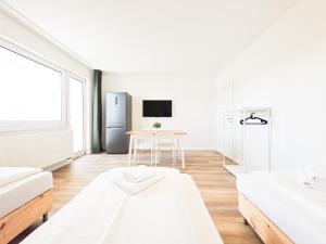 a white room with two beds and a table at Tolstov Apartments - Monteurwohnungen - 2 Schlafzimmer - Küche - Balkon - Waschmaschine in Heiligenhaus +19 photos
