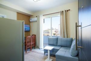 a living room with a blue couch and a window at Sea Vibe Apartment in Polisi i Vogël