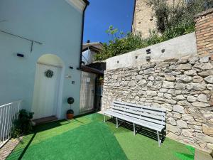 a white bench sitting in front of a stone wall at Rifugio Nel Cuore Dell'Abruzzo in Carpineto Sinello