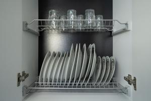 a shelf with a bunch of wine glasses on it at Sea Vibe Apartment in Polisi i Vogël