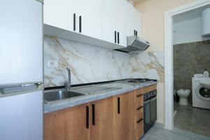 a small kitchen with a sink and a stove at Sea Vibe Apartment in Polisi i Vogël +20 photos