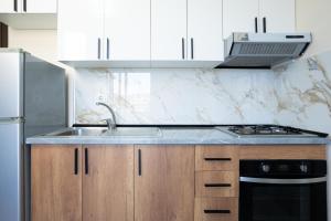 a kitchen with a sink and a stove top oven at Sea Vibe Apartment in Polisi i Vogël