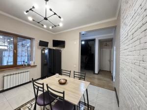 a dining room with a wooden table and chairs at Meridian Hostel in Almaty