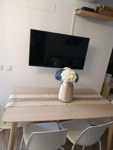 a dining room table with a vase of flowers on it at Casa Raios de Sol in Burgau
