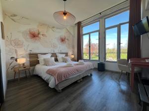 a bedroom with a bed with flowers on the wall at Logis Hôtel Auberge de Cartassac in Sarrazac +42 photos