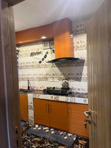 a kitchen with wooden cabinets and a brick wall at RYN Apartment Ayobo-Ishefun, Lagos Flat1 in Itele