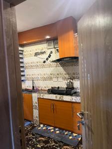 a kitchen with wooden cabinets and a tile wall at RYN Apartment Ayobo-Ishefun, Lagos Flat1 in Itele +32 photos