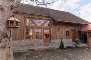 a wooden house with a large glass door at Rácz Vadászkúria in Racoşu de Sus