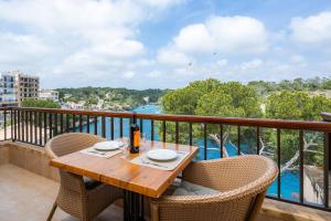 a table on a balcony with a view of the water at Cala Figuera Apartment 3b in Cala Figuera