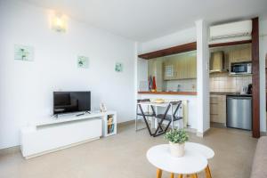 a living room with a tv and a kitchen at Cala Figuera Apartment 3b in Cala Figuera
