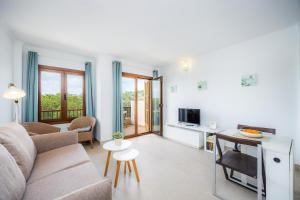 a living room with a couch and a tv at Cala Figuera Apartment 3b in Cala Figuera