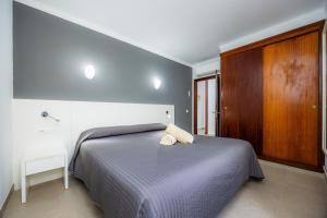a bedroom with a bed and a wooden cabinet at Cala Figuera Apartment 3b in Cala Figuera
