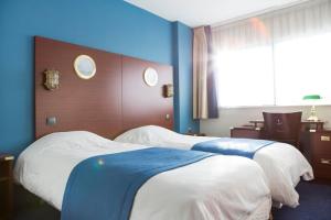 Ein Bett oder Betten in einem Zimmer der Unterkunft Hôtel Les Gens De Mer Dunkerque by Popinns