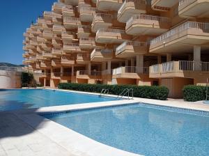 a building with a swimming pool in front of a building at Parquemar III-IV Solo Familias!!! Serviplaya in Playa de Xeraco