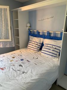 a bedroom with a bed with a blue headboard at Gîte du Phare in Lanquais