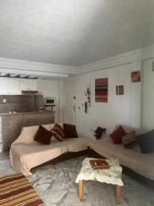 a living room with two beds and a table at S1 a louer in Dar el Saïd