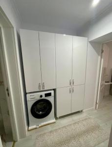 a kitchen with white cabinets and a washing machine at Luxbab in Drobeta-Turnu Severin