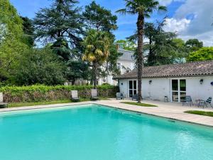 a swimming pool in front of a house at Manoir La Bordeneuve in Villeneuve-sur-Lot